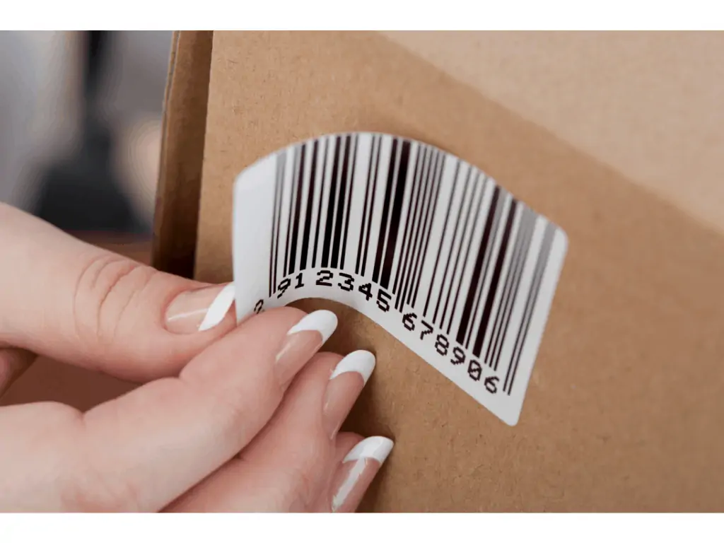 persons hand peeling of a barcode from a box 