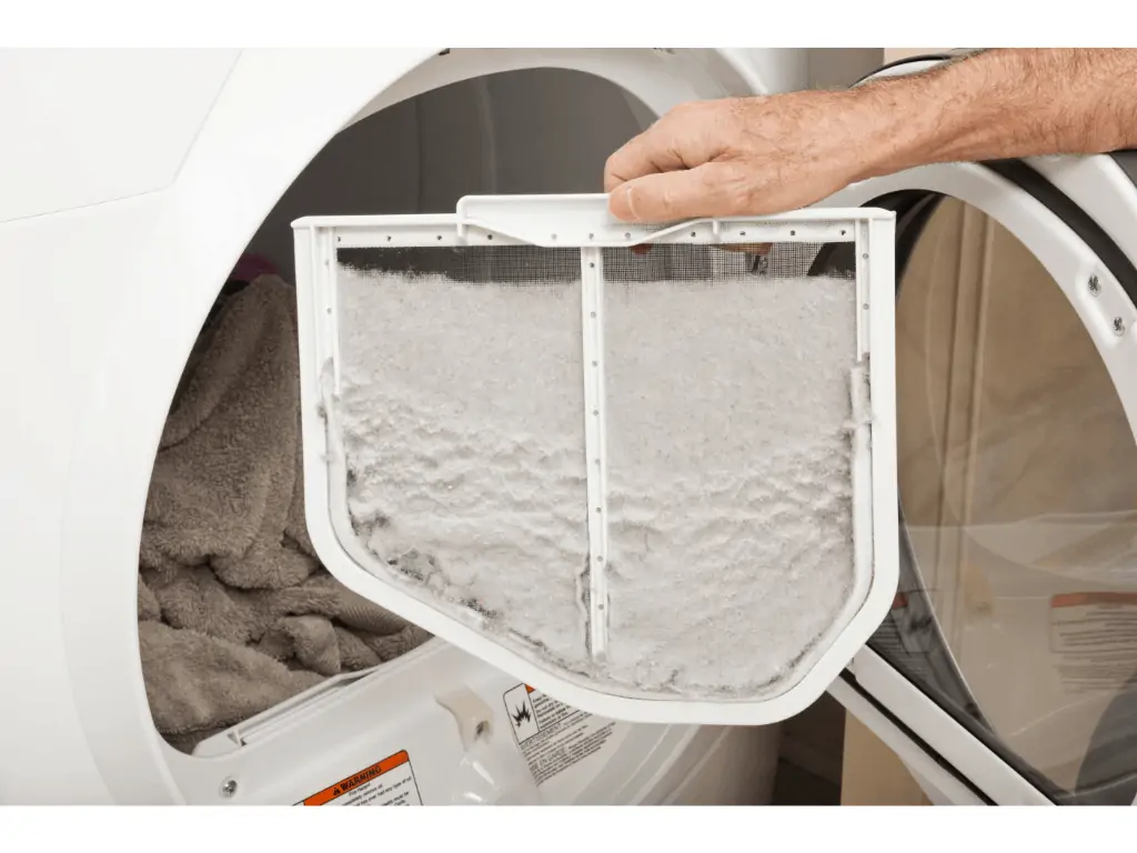person holding a lint from washing machine